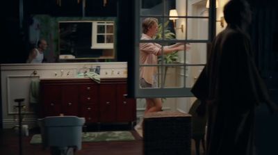 a woman standing in a kitchen next to a window