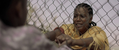 a woman holding a baseball bat behind a fence