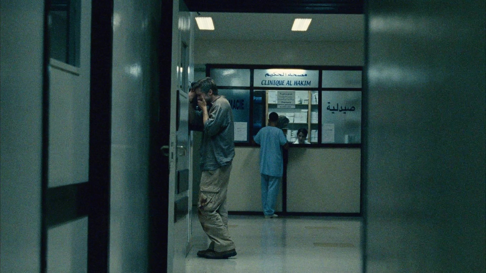 a man standing in a hallway talking on a cell phone