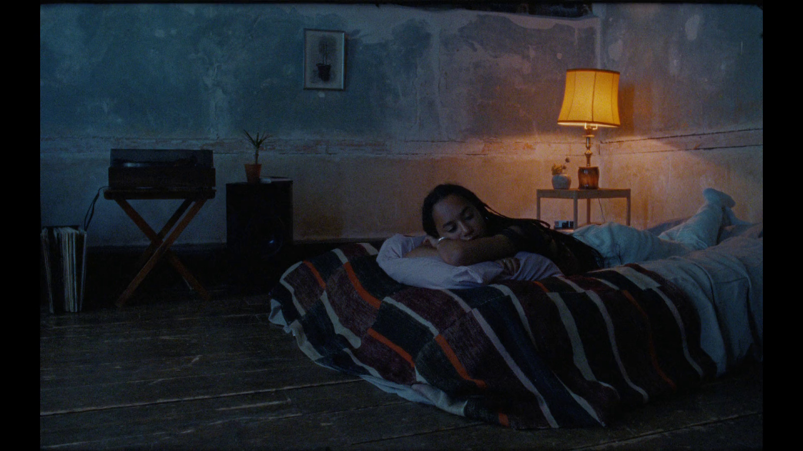 a woman laying on a bed in a dark room