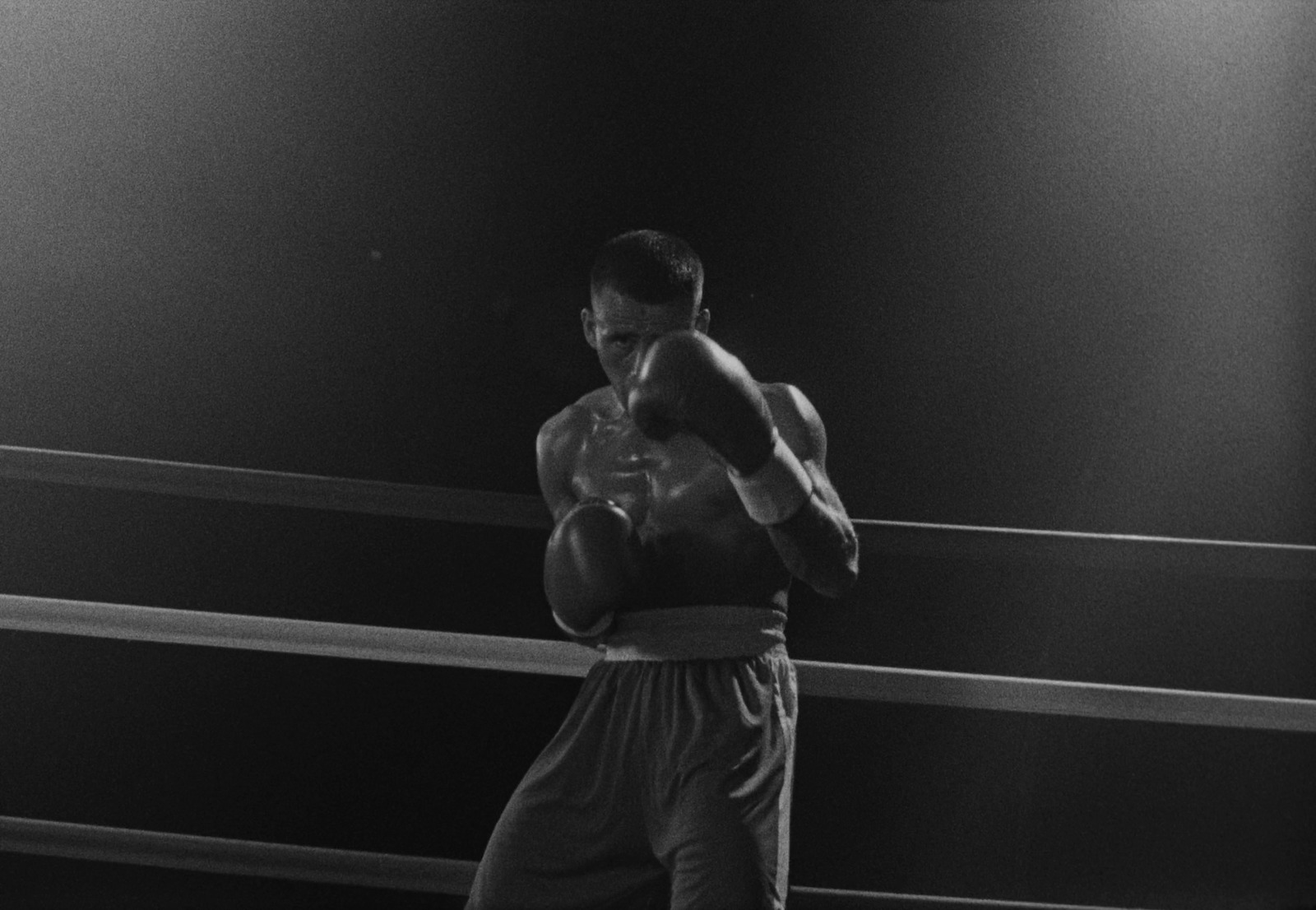 a black and white photo of a man in a boxing ring