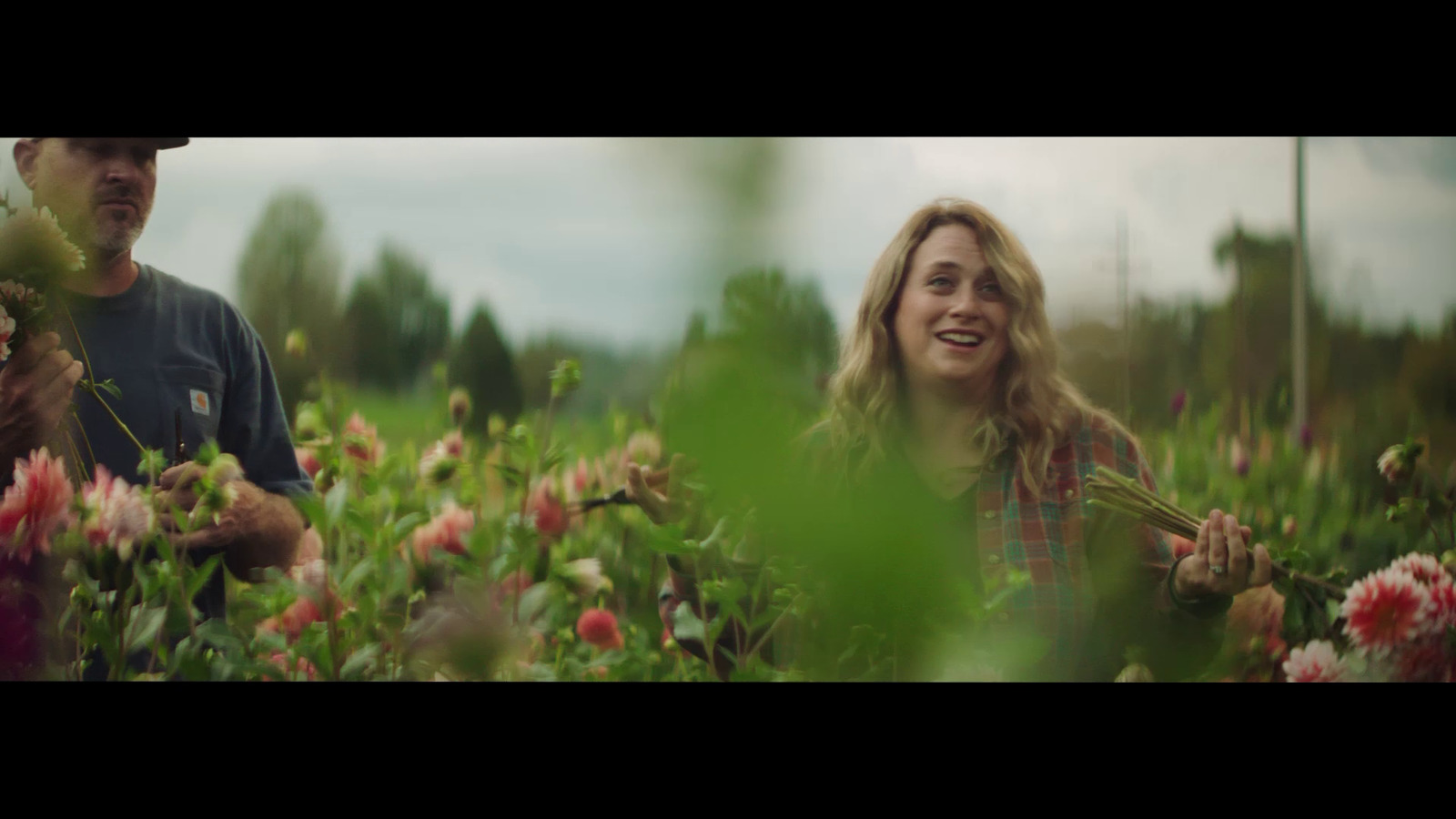 a man standing next to a woman in a field of flowers