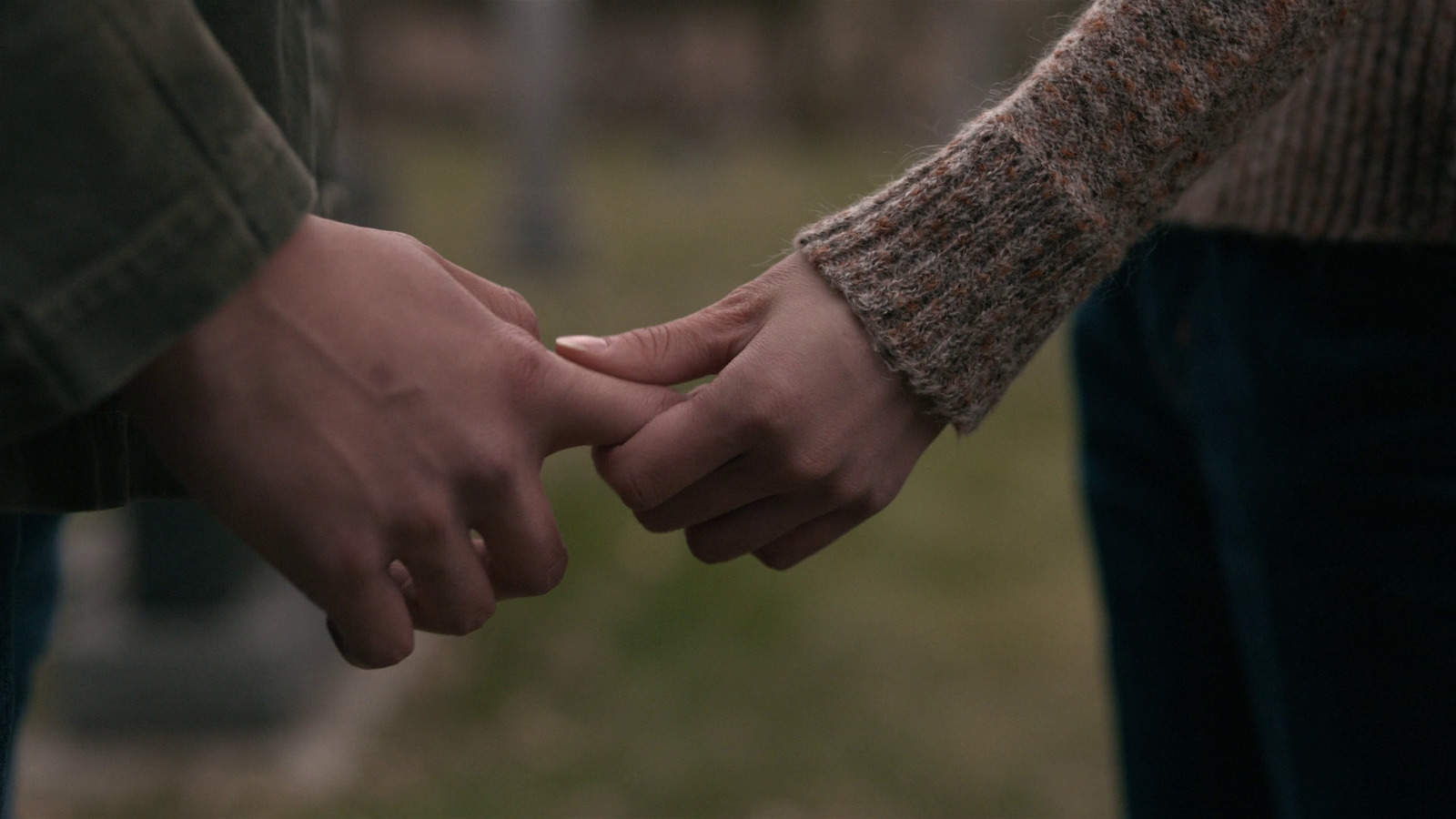 a close up of two people holding hands