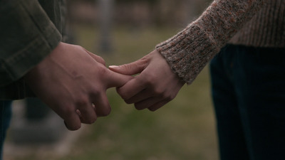 a close up of two people holding hands