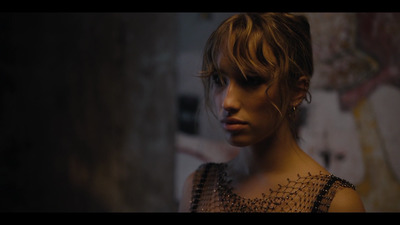 a woman in a black dress is staring into the distance