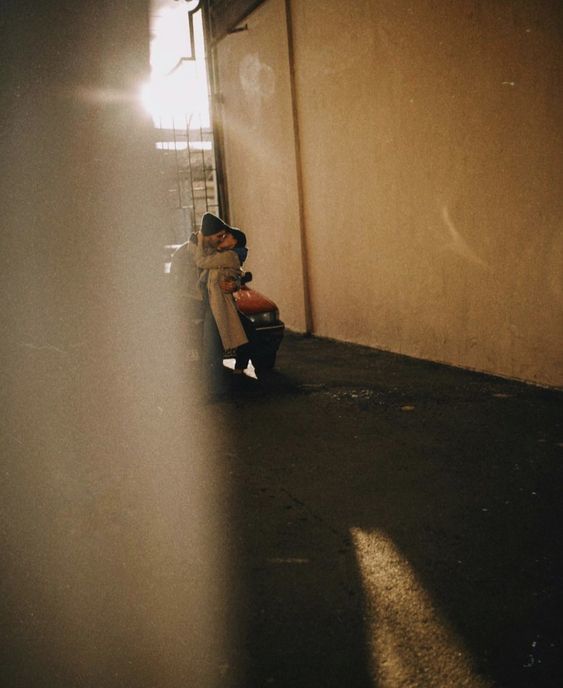 a person sitting on a scooter in an alley