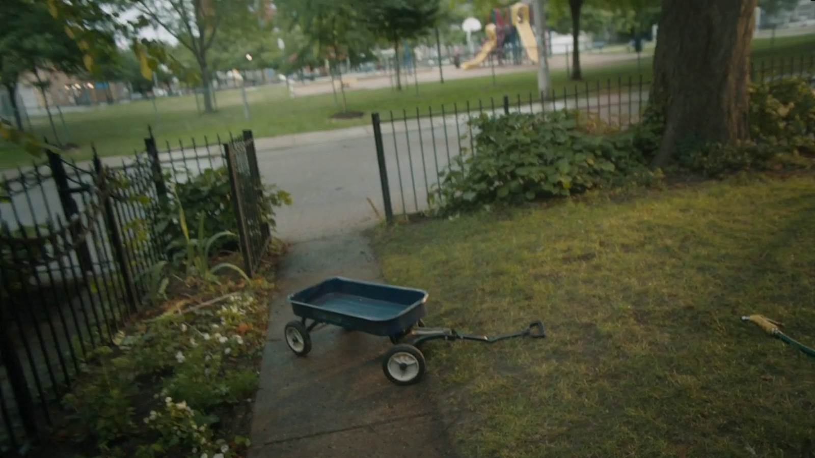 a wheelbarrow with a blue tray on a sidewalk