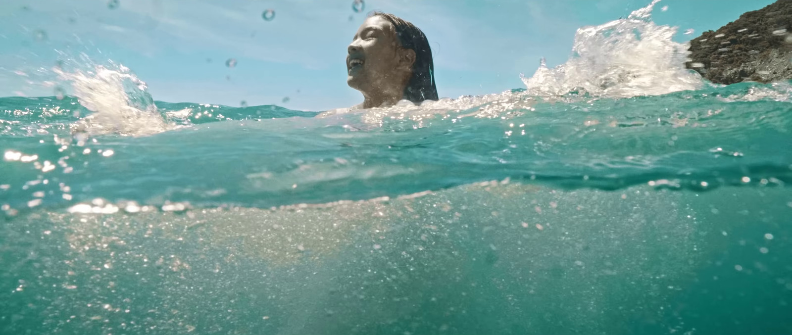 a man swimming in the ocean with his head above the water