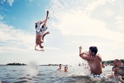 a man jumping into the water from a boat