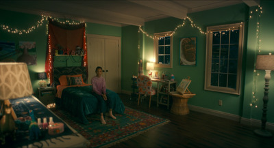 a woman sitting on a bed in a green room