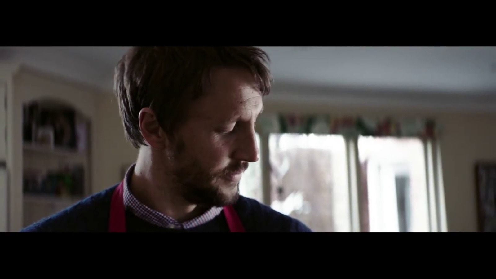 a man with an apron on looking at something