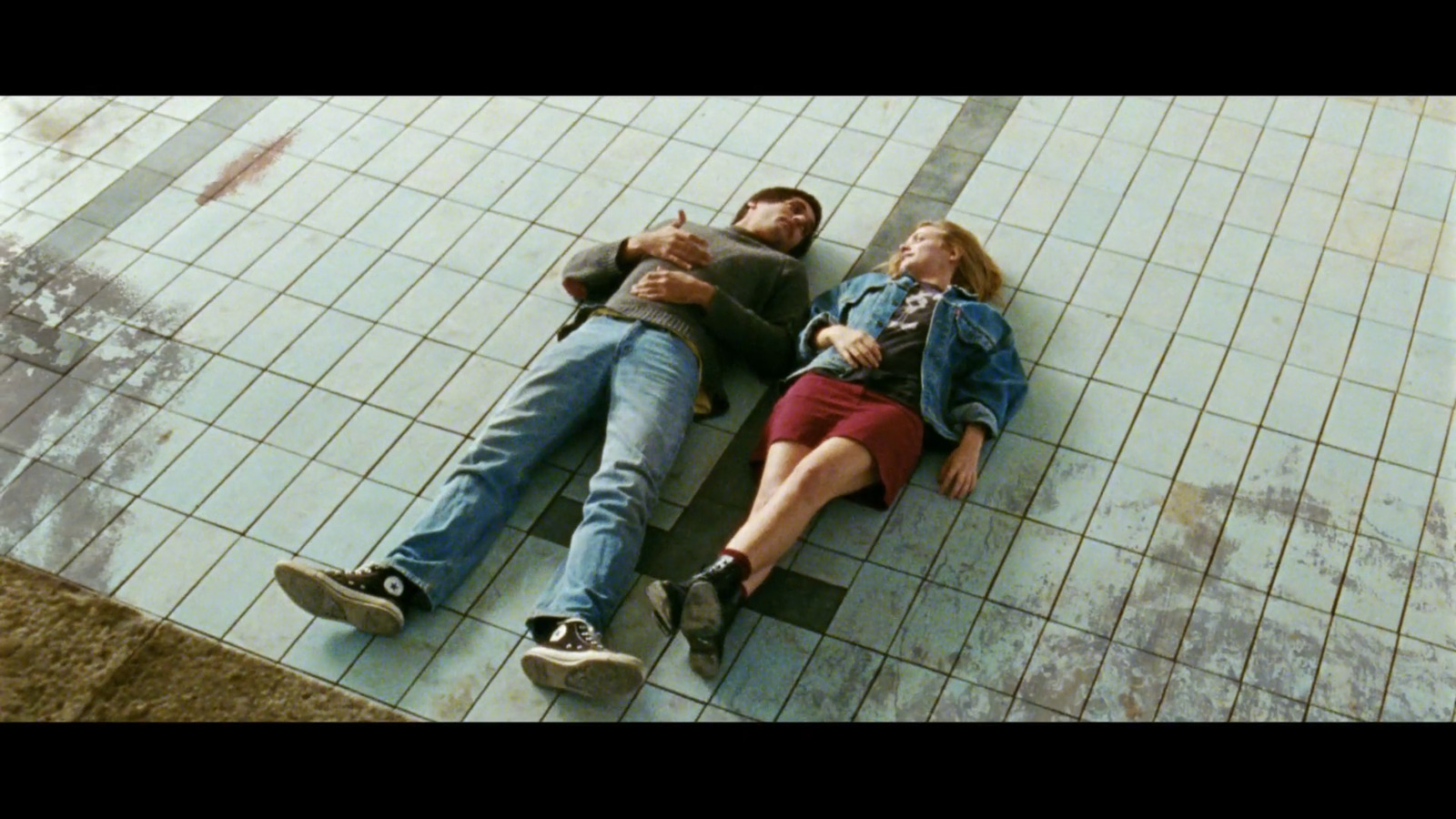 a man and a woman laying on a tiled floor