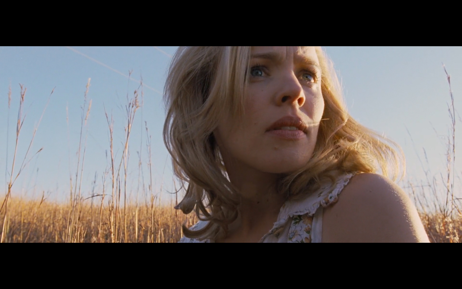 a woman standing in a field of tall grass