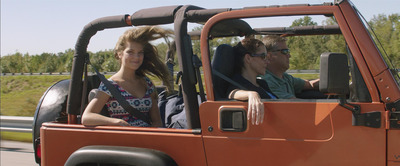 a man and a woman sitting in the driver's seat of a jeep