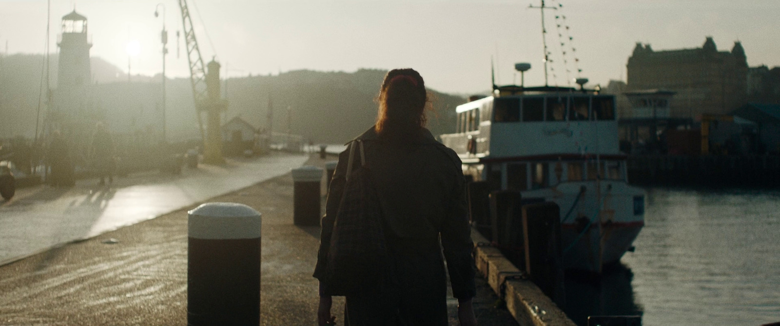 a woman standing on a dock next to a boat