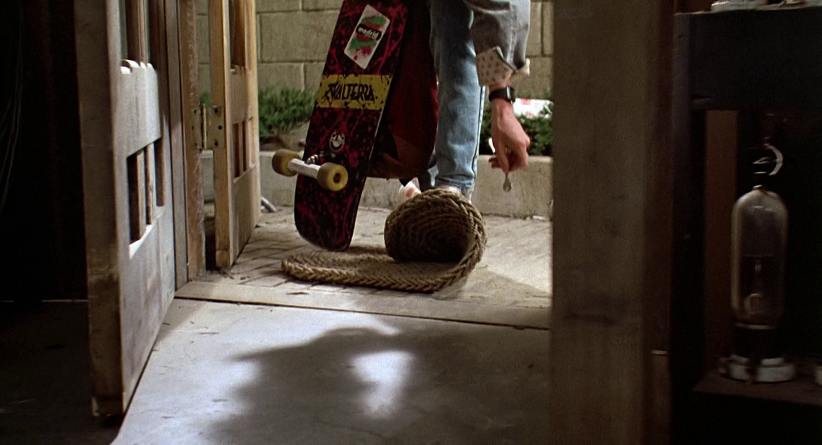 a person holding a skateboard in a doorway