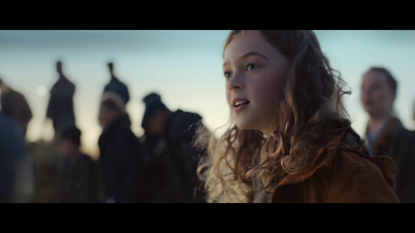 a young girl standing in front of a group of people