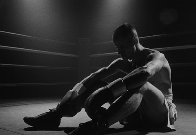 a man sitting on the ground in a boxing ring