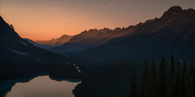 the sun is setting over a mountain range