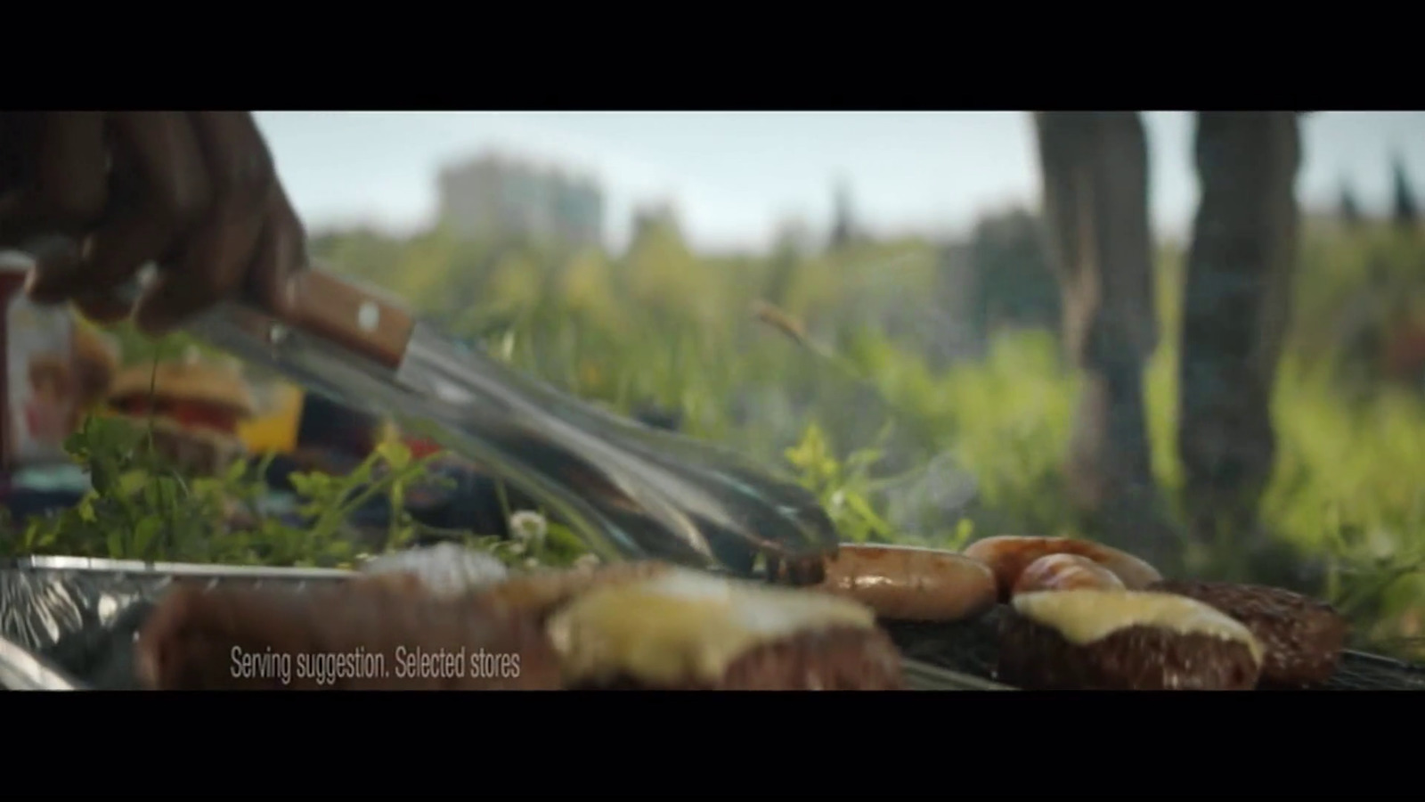 a person cooking food on a grill in a field