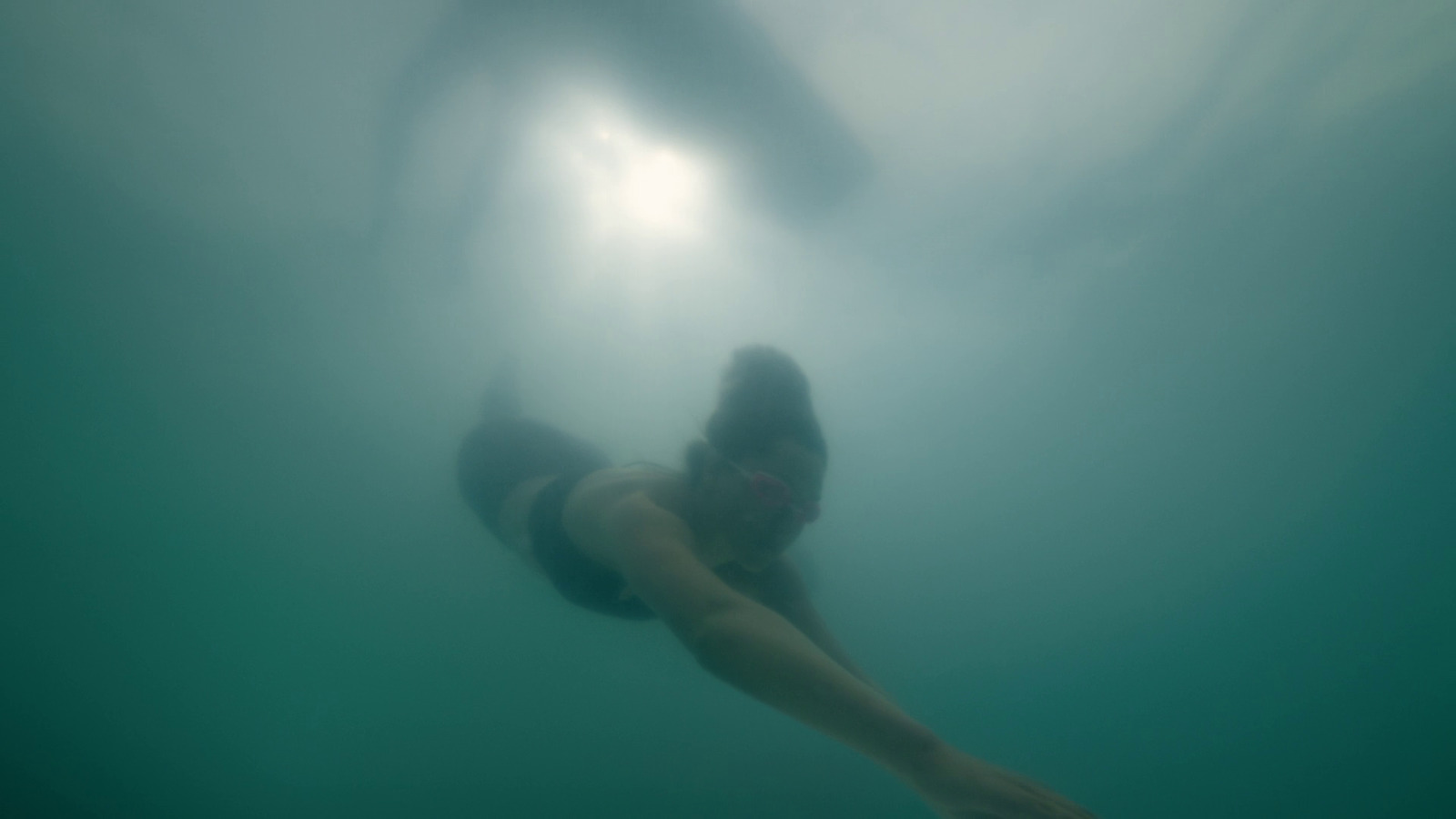 a woman in a bikini swims under the water