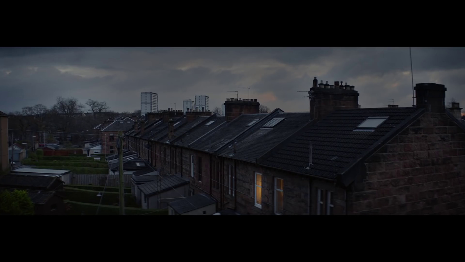 a row of houses with a cloudy sky in the background