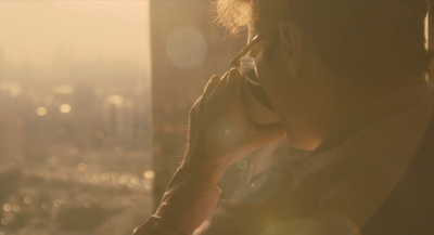 a man talking on a cell phone while standing in front of a window