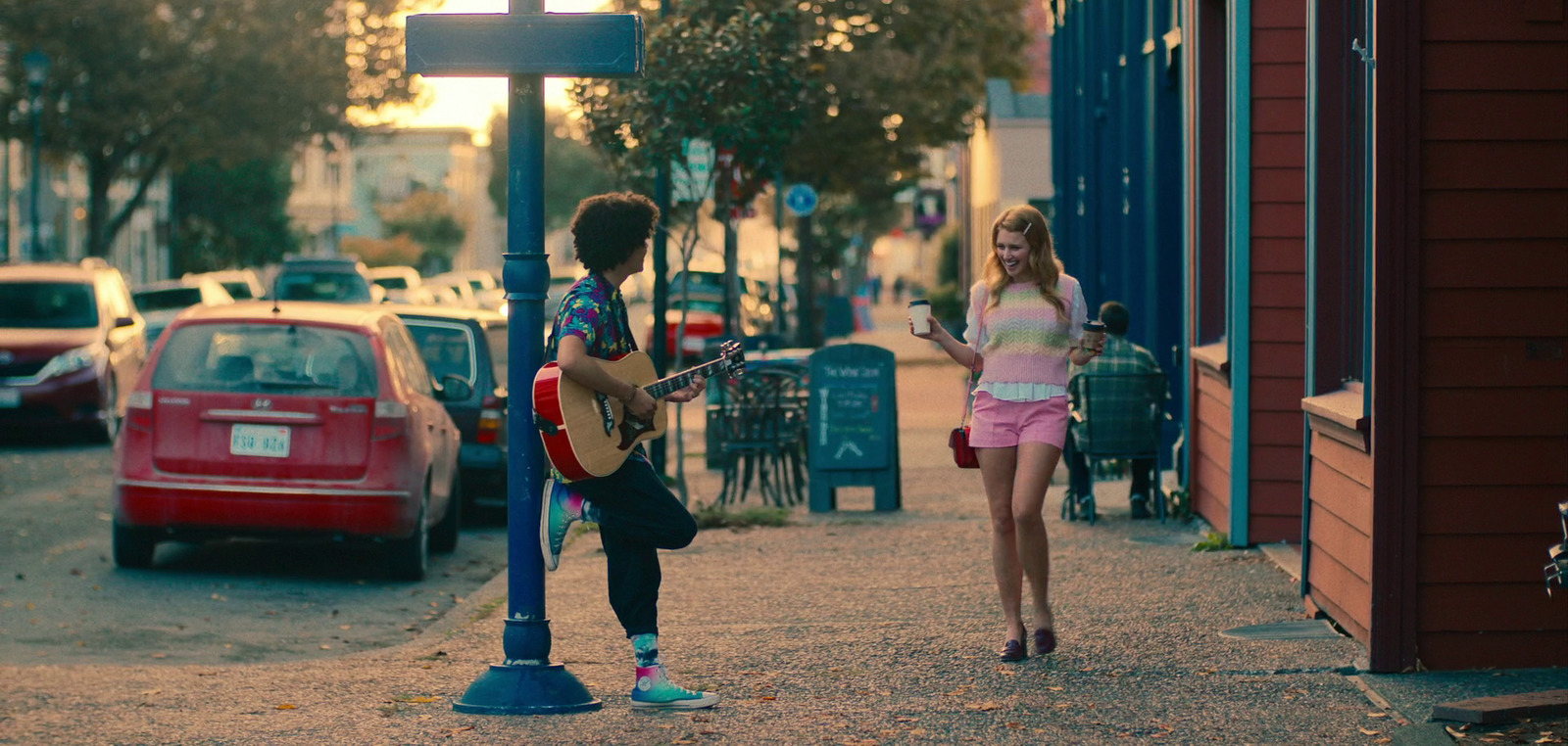 a man and a woman playing guitar on a city street