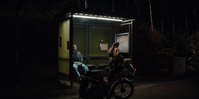 a man and a woman sitting on a motorcycle in the dark