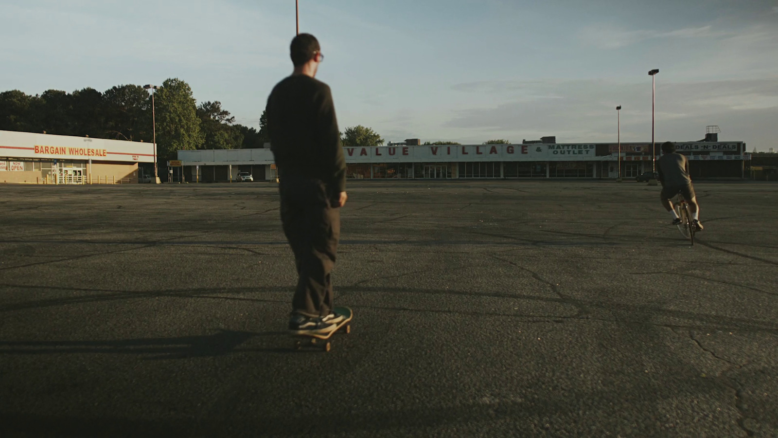 a man riding a skateboard across a parking lot