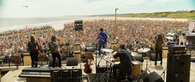 a large group of people standing on top of a beach