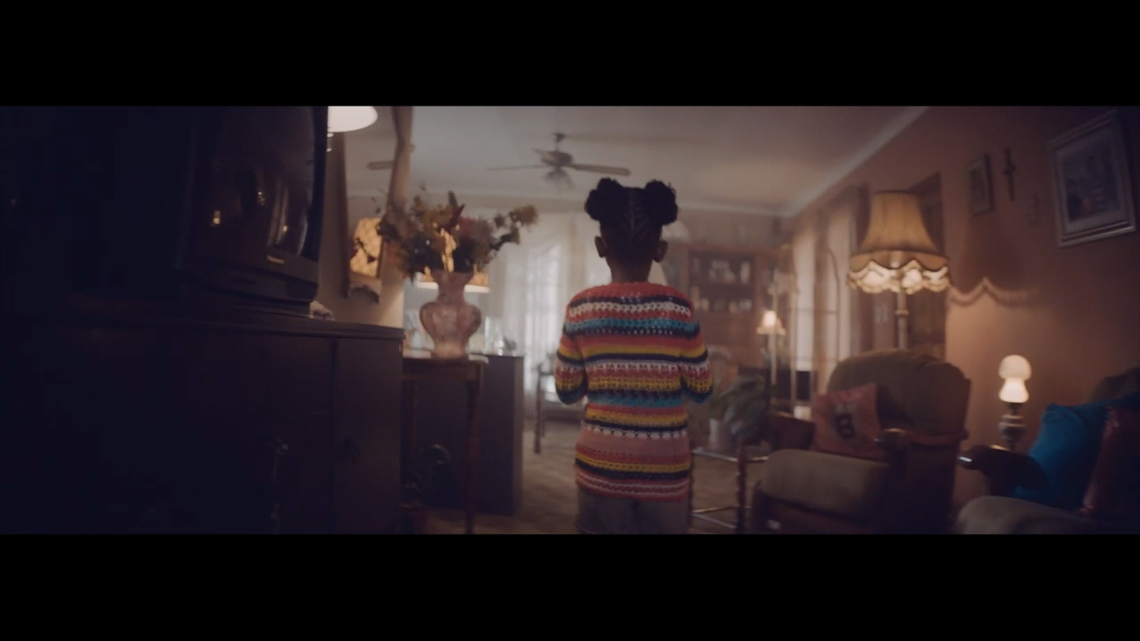 a woman standing in a living room next to a dresser