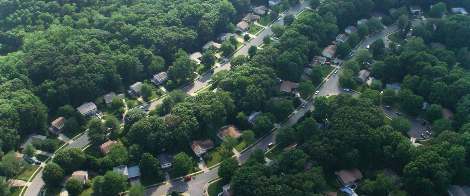 an aerial view of a residential neighborhood surrounded by trees