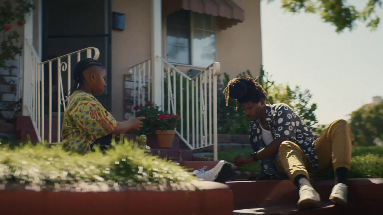 a man and woman sitting on the steps of a house