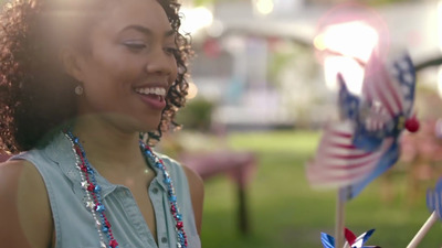 a woman standing next to a flag pinwheel