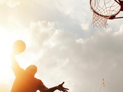 a man is playing basketball on a sunny day