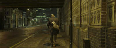 a man walking down a street at night