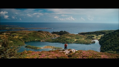 a man standing on top of a lush green hillside