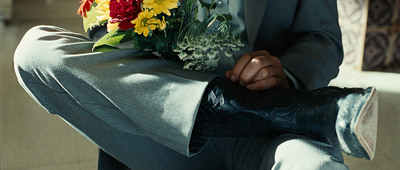 a man in a suit holding a bouquet of flowers