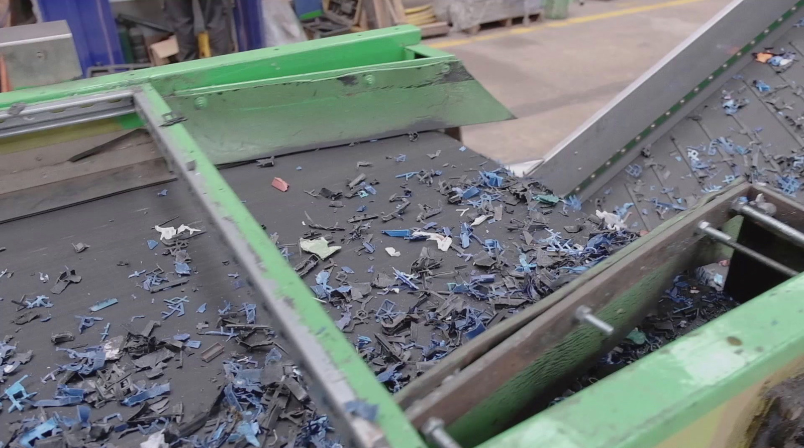 a conveyor belt filled with blue plastic debris