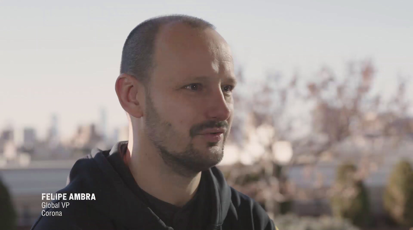 a man in a black hoodie looking at the camera