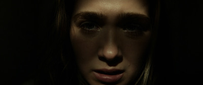 a woman's face is shown in the dark