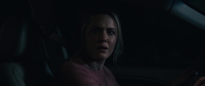 a woman sitting in a car in the dark