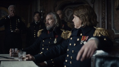 a man in uniform sitting at a table next to a woman