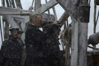 a group of men standing on top of a boat in the snow