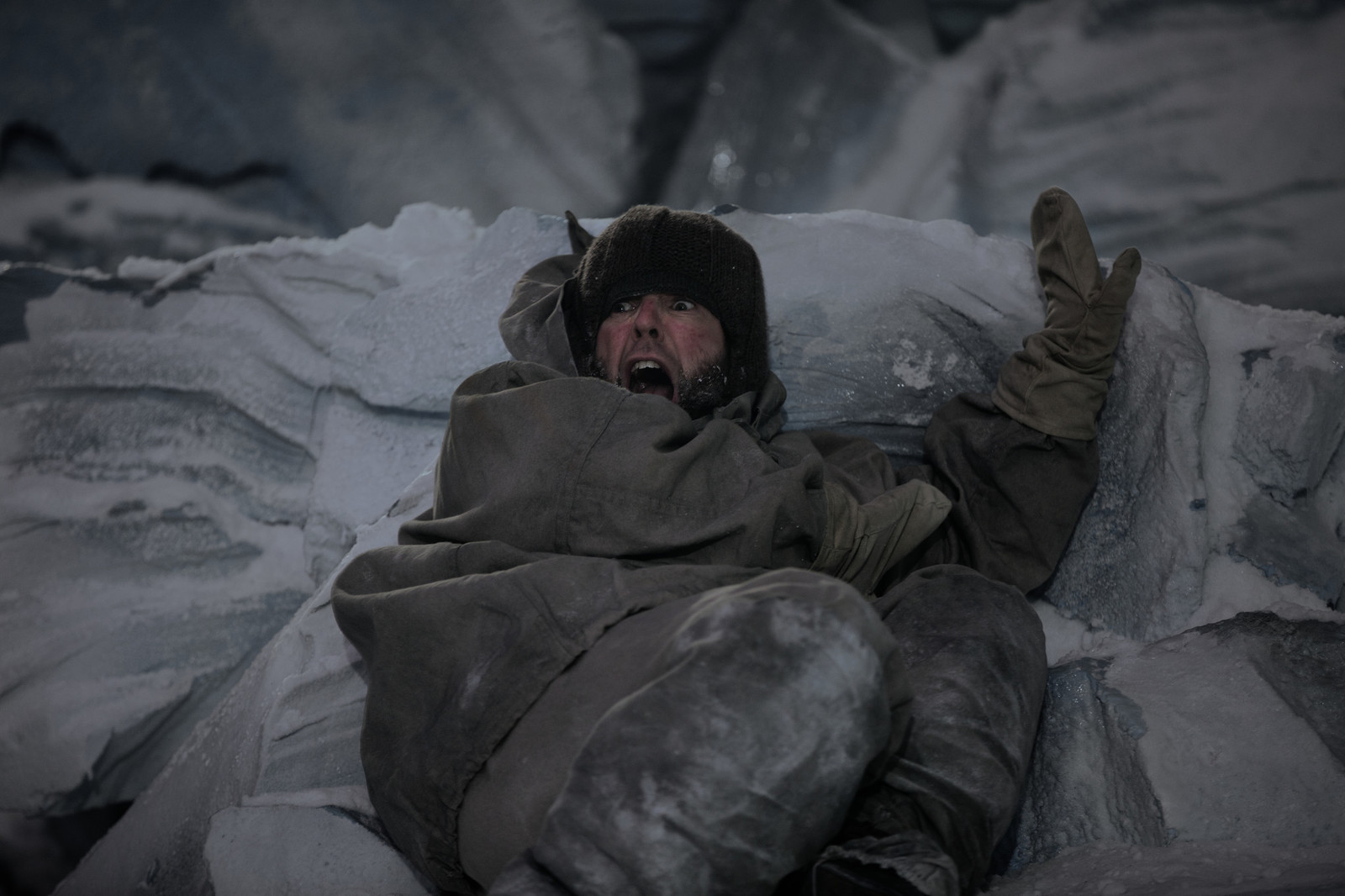 a man laying on top of a pile of ice