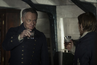 a man in uniform holding a glass of wine