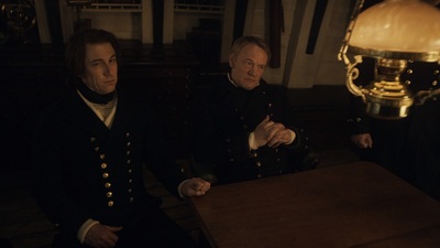 two men sitting at a table in a room