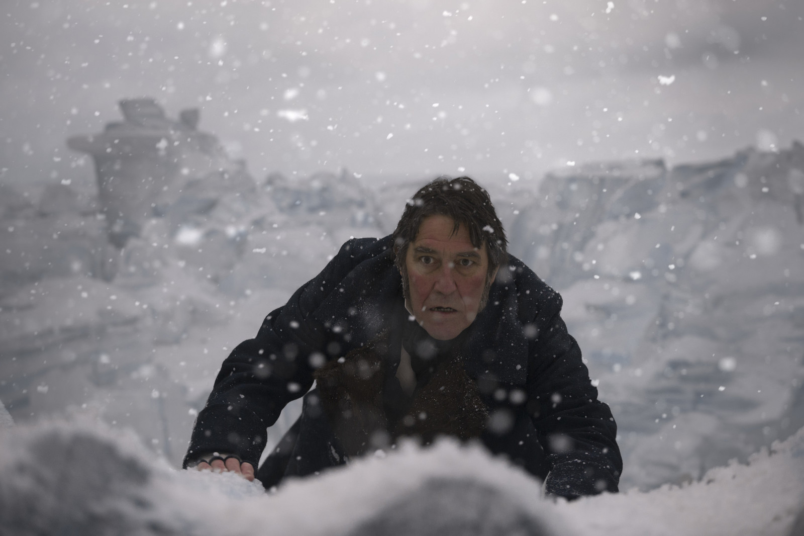 a man standing in the snow with his hand on his hip