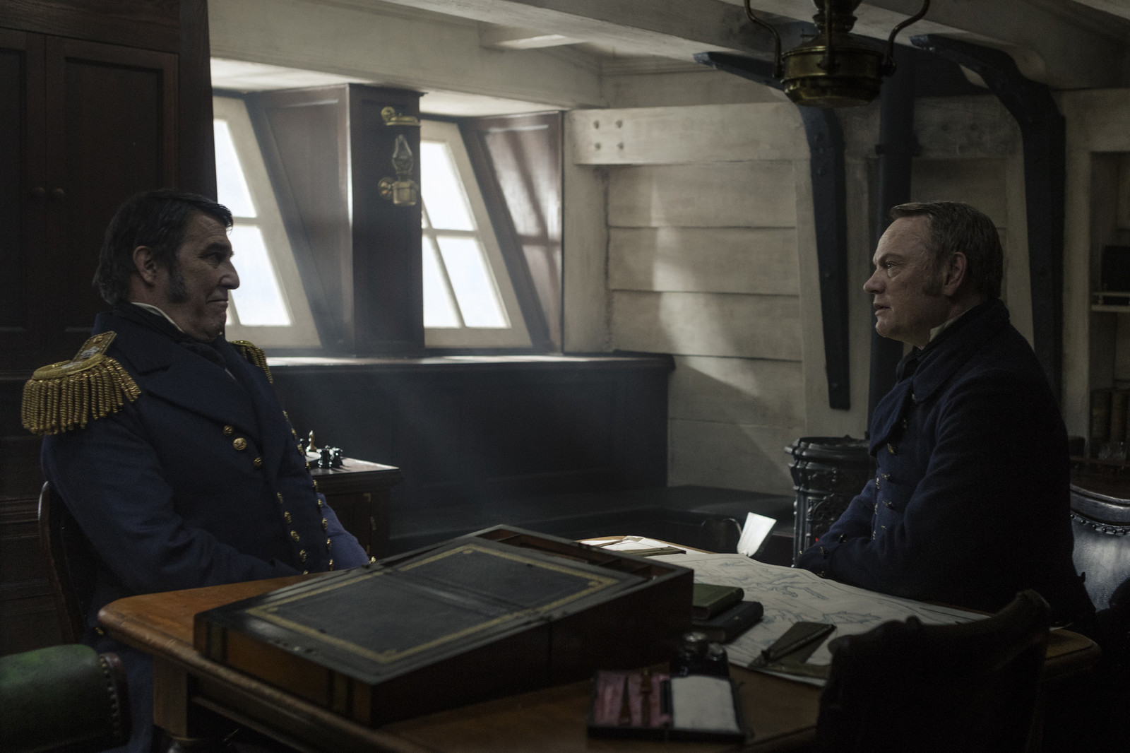 two men sitting at a table in a room